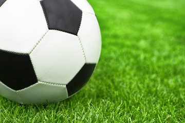 Plakat soccer ball on a green lawn close up