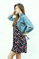 young girl in dress and denim waistcoat on a white isolated background