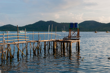 Fototapeta premium Small wood jetty in front of ocean and island