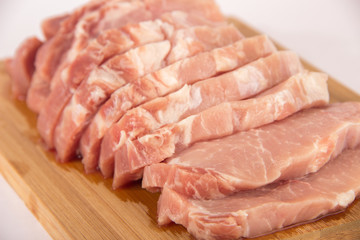 Raw piece of meat on a wooden board on a white background
