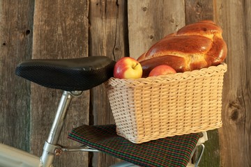 basket by bicycle with apples and pastries