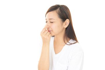 鼻をつまむ女性