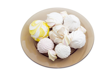 Various zefir and marshmallow on a dark glass dish