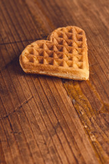Heart shaped homemade waffle on wooden desk