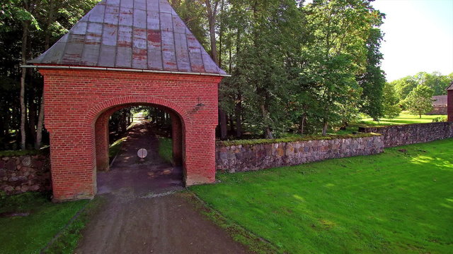 The red gate house of the Alatskivi manor in Estonia. The entrance gate going inside the manor in the middle of the forest