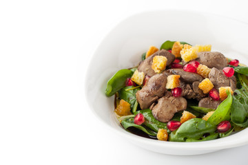 Salad with chicken liver and spinach in the white plate
