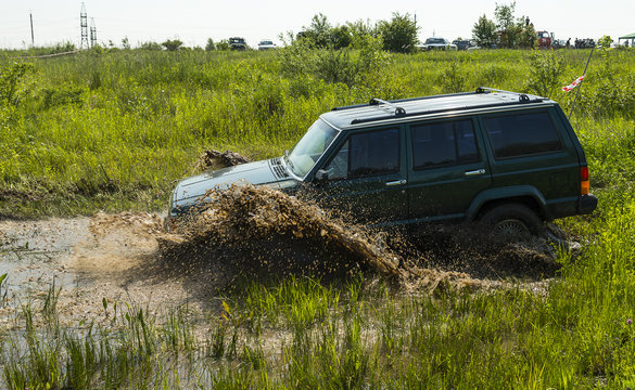 Off-road vehicle brand Jeep Cherokee overcomes a pit of mud