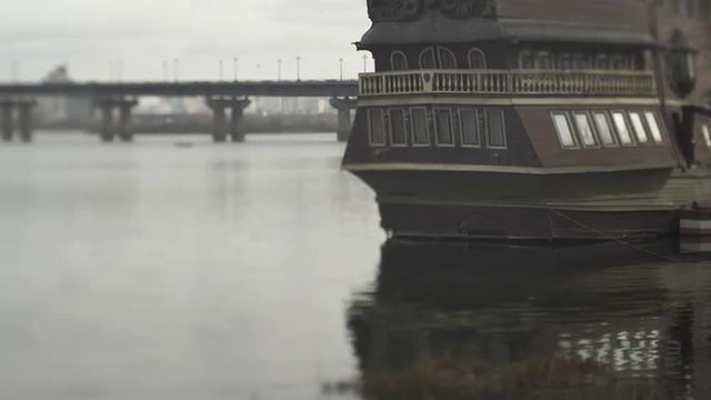 Small fishing boat anchored in the river next to a bridge.Ships in harbor.