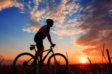 Obraz premium mountain biker silhouette in sunrise