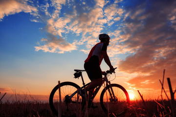 Fototapeta na wymiar mountain biker silhouette in sunrise