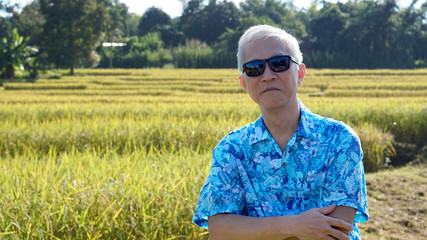 Naklejka na ściany i meble Asian guy in bright shirt at his SME farmland. Abstract own agri