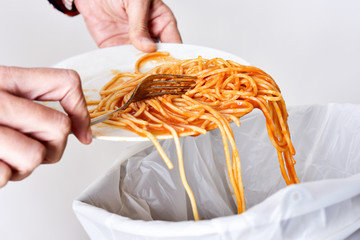 young man throwing leftovers to the trash bin