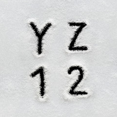 Winter alphabet, symbols and numbers hand written on snow.