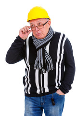 Thinking old senior man in sweater, jeans, scarf, glasses, wearing yellow construction hat. Holding and fixing his glasses with the finger. Isolated, plain white background
