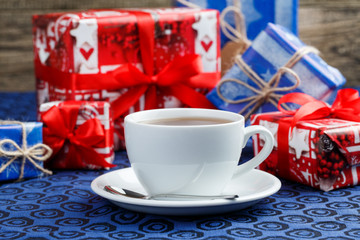 Christmas table with cup of tea and gifts.