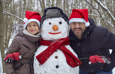 Winter fun. Family has built a funny snowman in the park