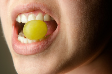 Lips biting on grape