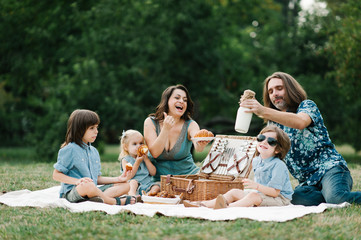 Happy young hipster family having fun, bowl, rising up, piggyback ride their children and relax for...