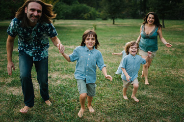 Happy young hipster family having fun while running, bowl,  rising up, piggyback ride their...