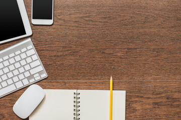 Office wooden table with notebook, yellow pencil, tablet, keyboa