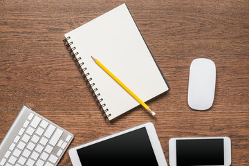 Office wooden table with notebook, yellow pencil, tablet, keyboa