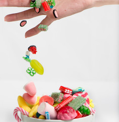 Fototapeta na wymiar hand with colorful candy on white background, kids holidays