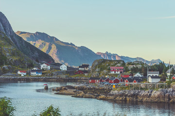 Fototapeta na wymiar Small seaside town situated at the foot of a mountain in sunset light Norway
