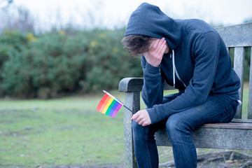 Depressed Teenage Boy Holding A Pride Flag