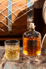 Glass of whiskey with ice and a bottle