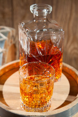 Glass of whiskey with ice and a decanter