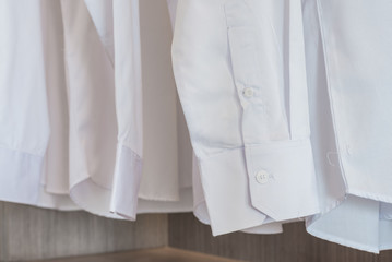 shirts hanging on rack with white buttons