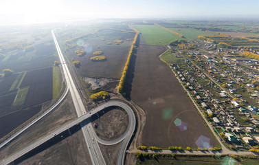 Fototapeta premium Aerial road interchange, viaduct. Crossroads view parking lots, bridges. Copter shot. Panoramic image