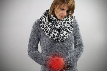 gastroenteritis - woman touching her belly