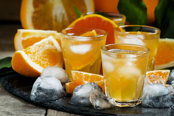 Alcoholic cocktail of orange juice, ice and soda, selective focu