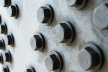 Gray metal surface with hexagonal bolt heads