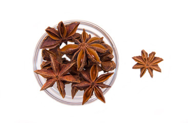 Star anise on bowl on a white background seen from above