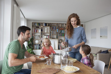 Couple with two children going to have lunch together at home