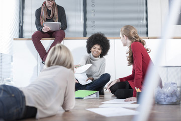 Colleagues with papers on office floor