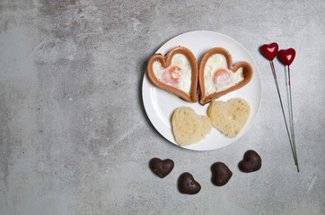 Dwa smażone jajka w kształcie serca na kamiennym tle © Patryk Michalski