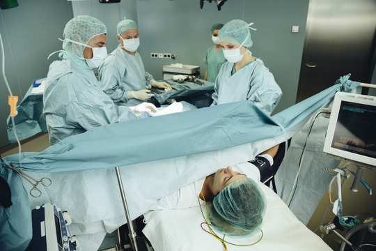 Team operating a woman on surgery table