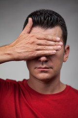 Fototapeta premium Young handsome covering his face with his hand