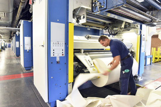 Man working at printing machine in a printing shop