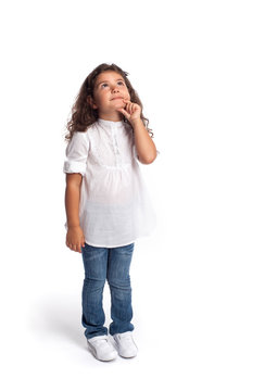 Full length portrait of a happy little girl looking up on white background