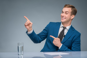 Smiling newscaster is posing at his workplace.