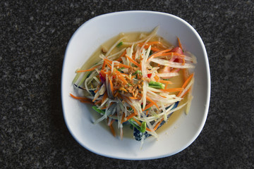 Fresh made hot and spicy papaya salad Som Tam with bean, carrot and peanuts. Traditional thai cuisine.