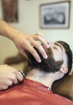 Barber shaving beard of a customer