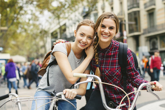 Spain, Barcelona, two young women on bicycles in the city
