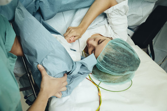 Mother touching her newborn right after c-section