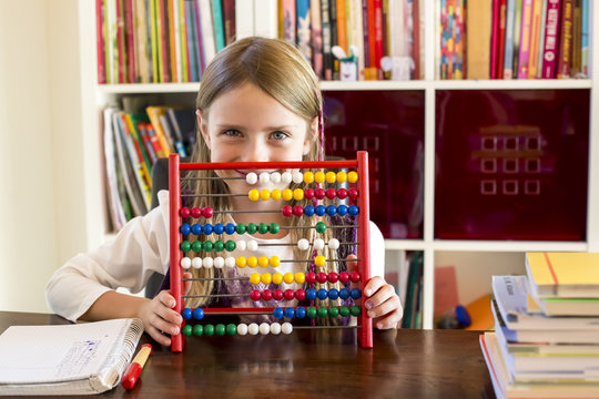 Smiling little girl sitting behind abacus