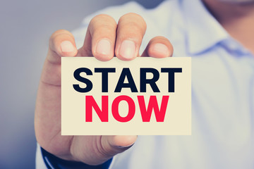 START NOW message on the card shown by a man